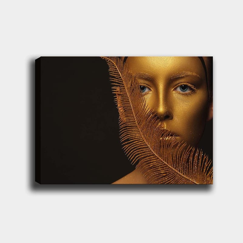 Canvastavla 70x100 cm - Ansiktsporträtt med en gyllene yta och blå ögon, omgiven av en dekorativ fjäderliknande struktur - Guld / Blå - Inredning & dekor - Tavlor & konst - Canvastavla