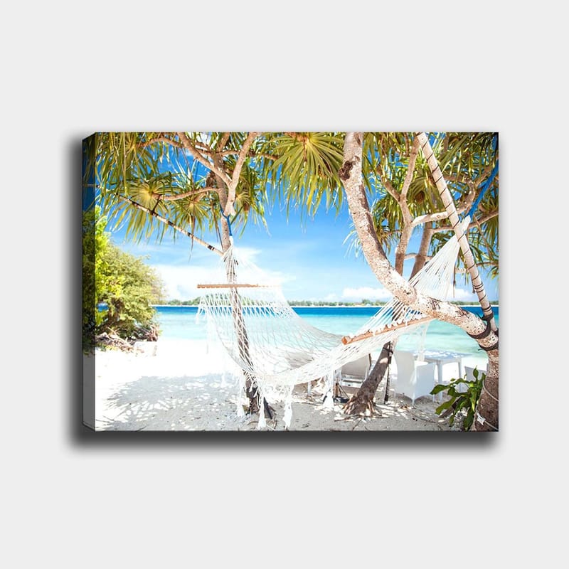 Canvastavla 70x100 cm - Avkopplande hängmatta mellan palmer vid en strand med turkost vatten och klarblå himmel, Vit / Blå / Grön