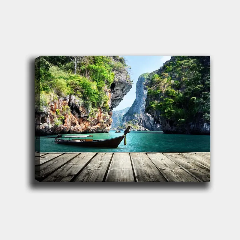 Canvastavla 70x100 cm - Båt ligger stilla vid en klippig strand omgiven av grönskande berg och klart vatten, Grön / Blå / Brun