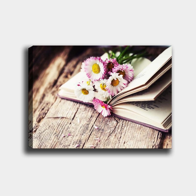 Canvastavla 70x100 cm - Bukett med blommor placerad på en öppen bok, Vit / Rosa / Gul