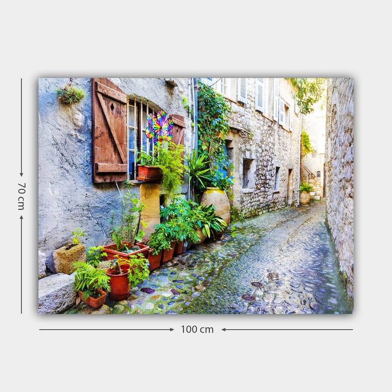 Canvastavla 70x100 cm - Charmig gränd med stenhus och blomsterkrukor som skapar en livlig atmosfär - Grön / Blå / Beige - Inredning & dekor - Tavlor & konst - Canvastavla