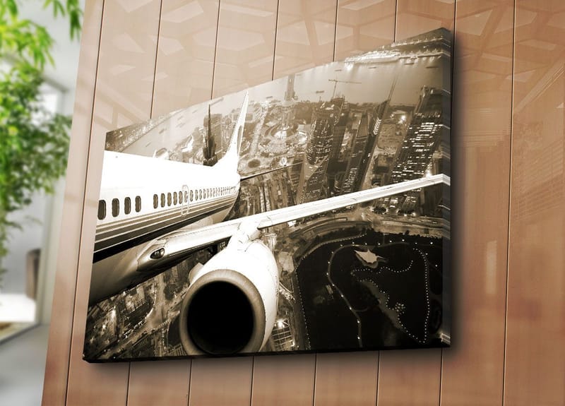 Canvastavla 70x100 cm - Ett flygplan som svävar över en stad i skymningsljus - Svart / Vit / Grå - Inredning & dekor - Tavlor & konst - Canvastavla