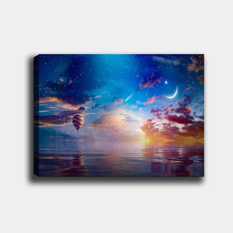 Canvastavla 70x100 cm - Färgglad luftballong svävar över en spegelblanka yta under en stjärnklar himmel med dramatiska moln och en måne, Blå / Orange / Röd
