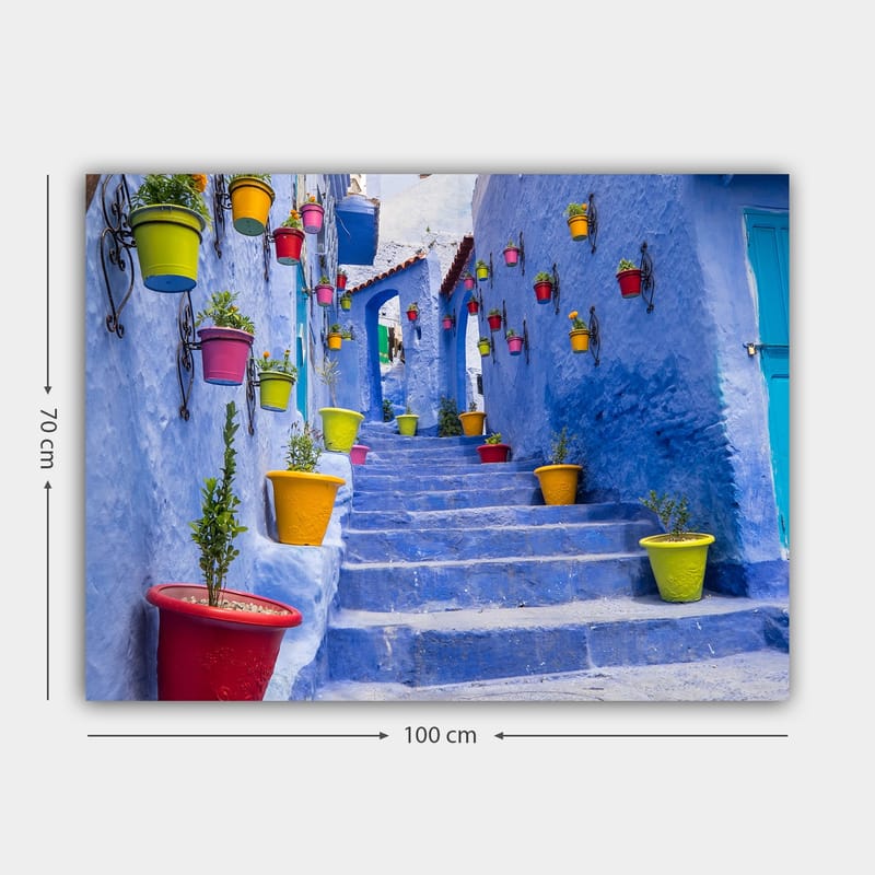 Canvastavla 70x100 cm - Färgglad trappa omgiven av blomkrukor i en pittoresk, blå stadsmiljö - Blå / Gul / Röd - Inredning & dekor - Tavlor & konst - Canvastavla