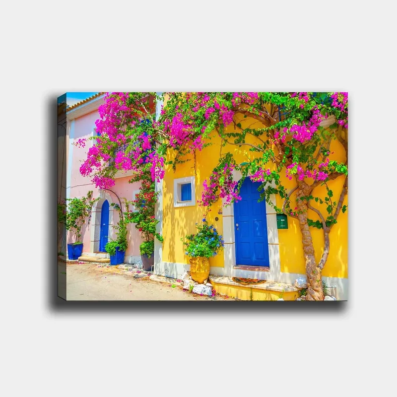 Canvastavla 70x100 cm - Färgglada hus med bougainvillea som blommar i en livlig gata, Blå / Gul / Rosa
