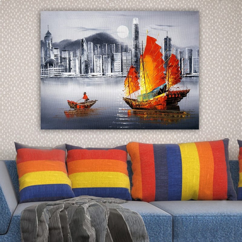 Canvastavla 70x100 cm - Färgstark segelbåt med röda segel på en spegelblanka vattenyta, omgiven av en modern stadsbild - Röd / Orange / Blå - Inredning & dekor - Tavlor & konst - Canvastavla