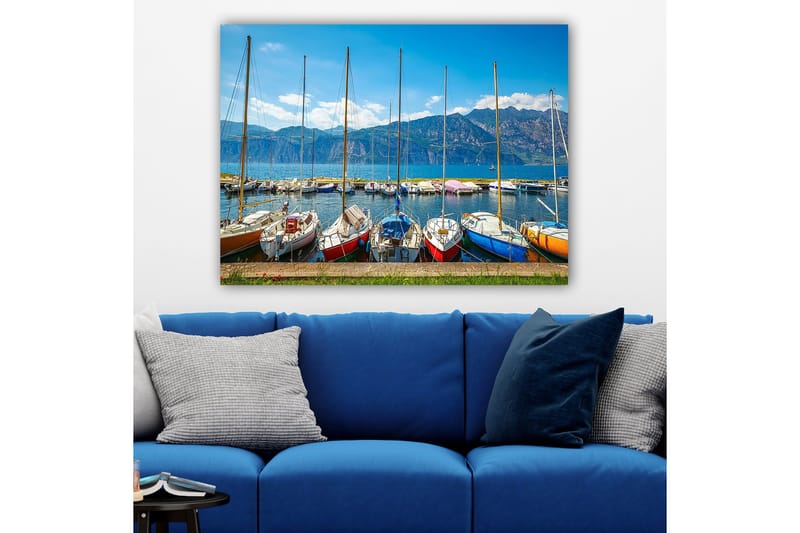 Canvastavla 70x100 cm - Flera färgglada segelbåtar vid en hamn med berg i bakgrunden, Blå / Röd / Orange