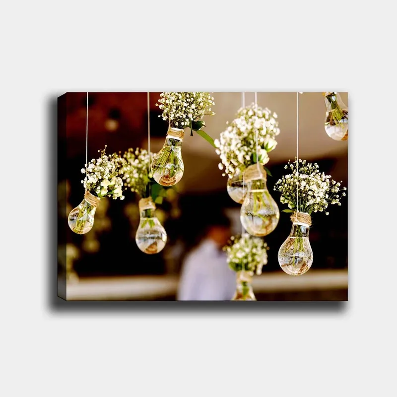 Canvastavla 70x100 cm - Hängande glödlampor med blommor som skapar en romantisk och kreativ atmosfär, Grön / Vit / Brun