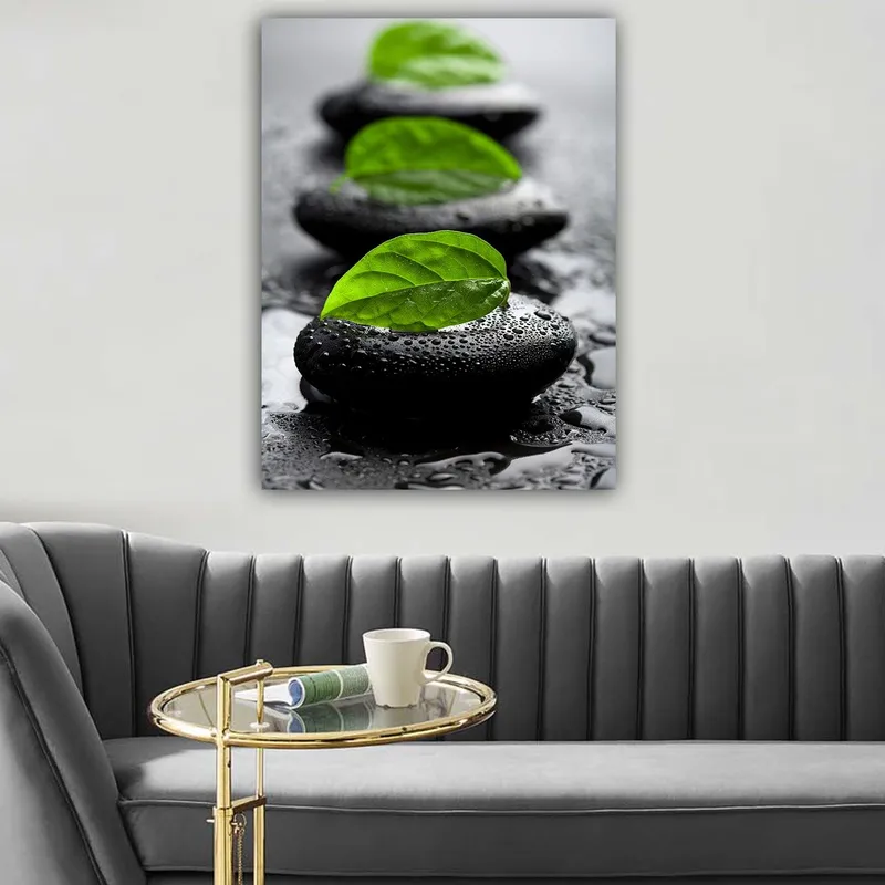 Canvastavla 70x100 cm - Harmonisk komposition av svarta stenar med gröna blad som symboliserar lugn och balans, Svart / Grön