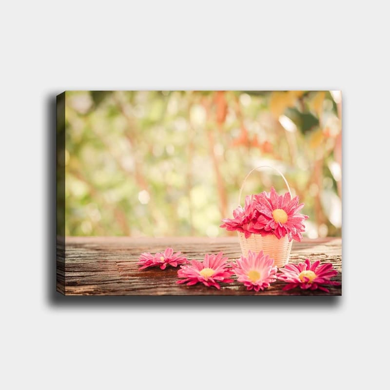 Canvastavla 70x100 cm - Korg fylld med rosa blommor på en träyta, Rosa / Gult / Brunt