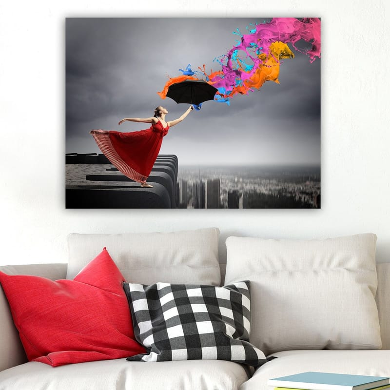 Canvastavla 70x100 cm - Kvinna i röd klänning står på en kant och håller ett paraply, medan färgglada färgstrålar sprutar ut från det - Röd / Svart / Orange - Inredning & dekor - Tavlor & konst - Canvastavla