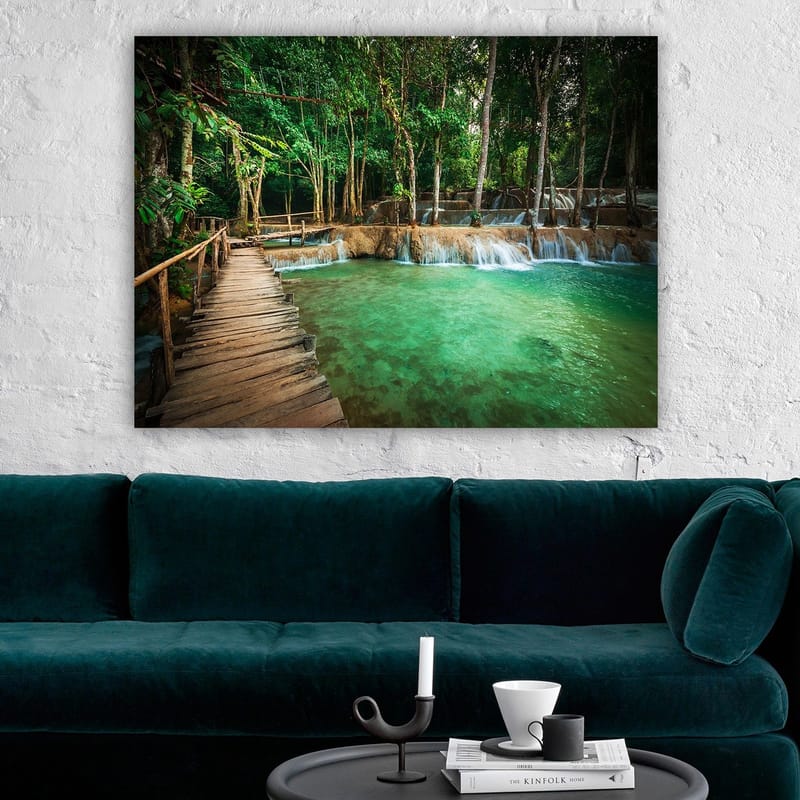 Canvastavla 70x100 cm - Lugn och naturskön plats med en träbro som leder över en klar, turkos vattenfallspool omgiven av frodig grönska - Turkos / Grön / Brun - Inredning & dekor - Tavlor & konst - Canvastavla