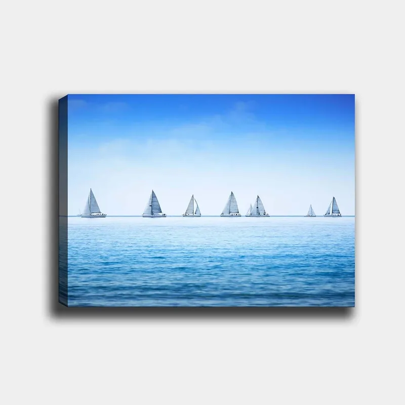 Canvastavla 70x100 cm - Segelbåtar som glider fram över en lugn sj ö under en klar blå himmel, Blå / Vit