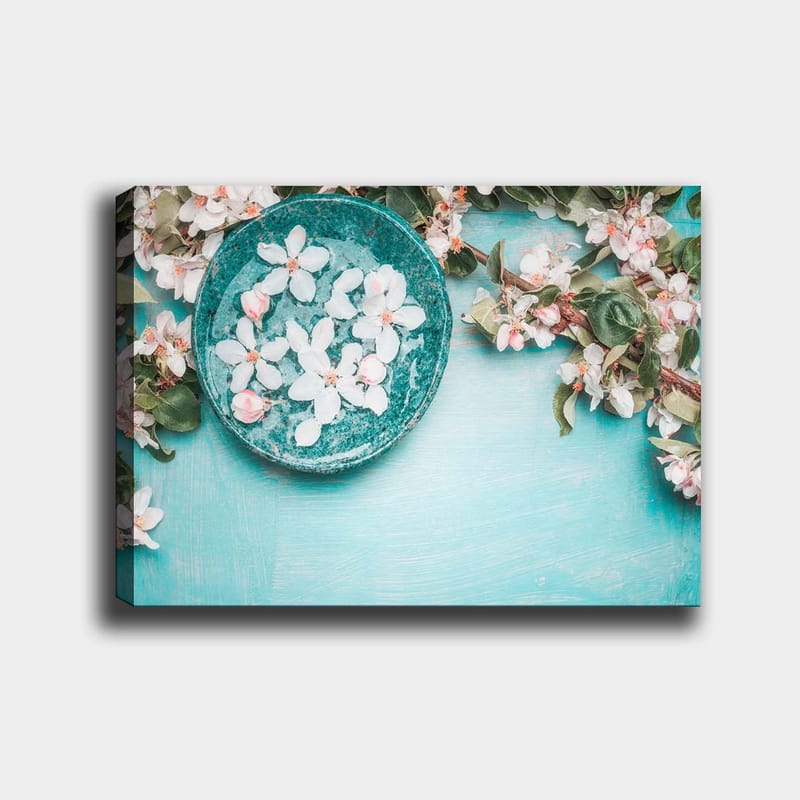 Canvastavla 70x100 cm - Skål med blommor omgiven av grönskande kvistar och blommor på en ljusblå bakgrund - Turkos / Vit / Rosa - Inredning & dekor - Tavlor & konst - Canvastavla