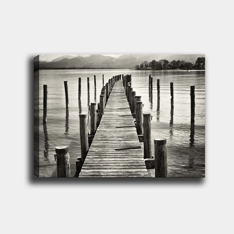 Canvastavla 70x100 cm - Stilla brygga som sträcker sig ut över vattnet, omgiven av pelare som reflekteras i ytan, Svart / Vitt / Grått