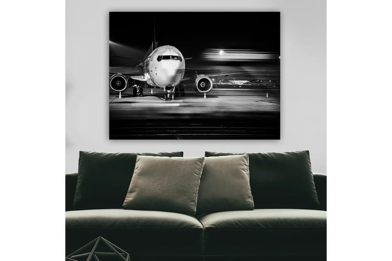 Canvastavla 70x100 cm - Svartvit bild av ett flygplan på en flygplats under natten, Svart / Vitt / Grått