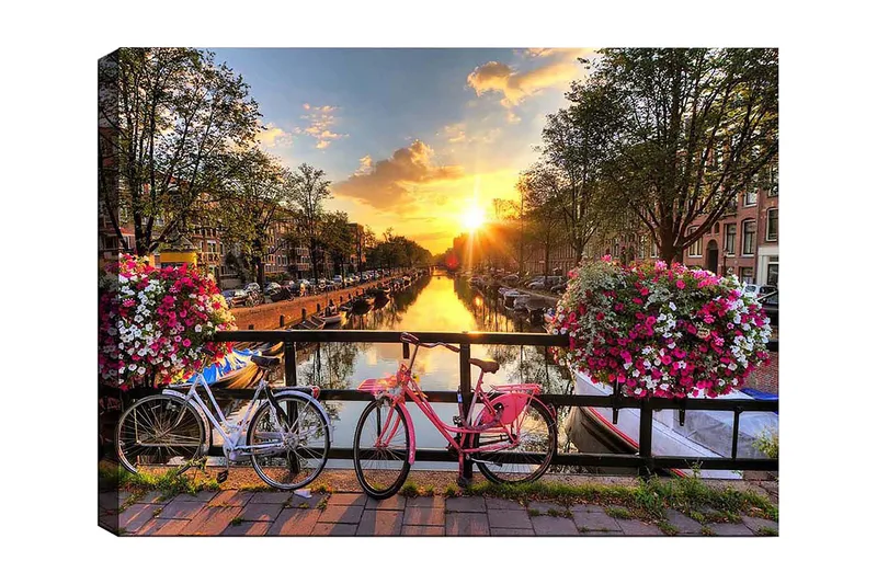 Canvastavla 70x100 cm - Två cyklar i en pittoresk kanalmiljö med blommor och solnedgång, Rosa / Vit / Grön