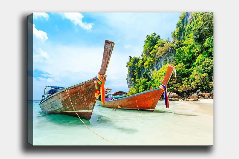 Canvastavla 70x100 cm - Två traditionella thailändska långbåtar vid en strand med klippor och grönskande vegetation i bakgrunden, Brun / Grön / Blå