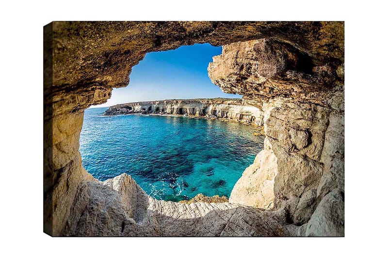 Canvastavla 70x100 cm - Utsikt genom en klippöppning mot en klarblå havsstrand, Blå / Beige / Vit
