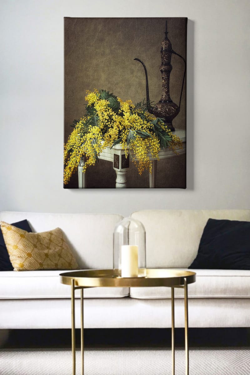 Canvastavla 70x100 cm - Vacker bukett av mimosa blommor i gult, placerad på ett bord bredvid en elegant, mörkbrun kanna - Gult / Mörkgrönt / Brunt - Inredning & dekor - Tavlor & konst - Canvastavla