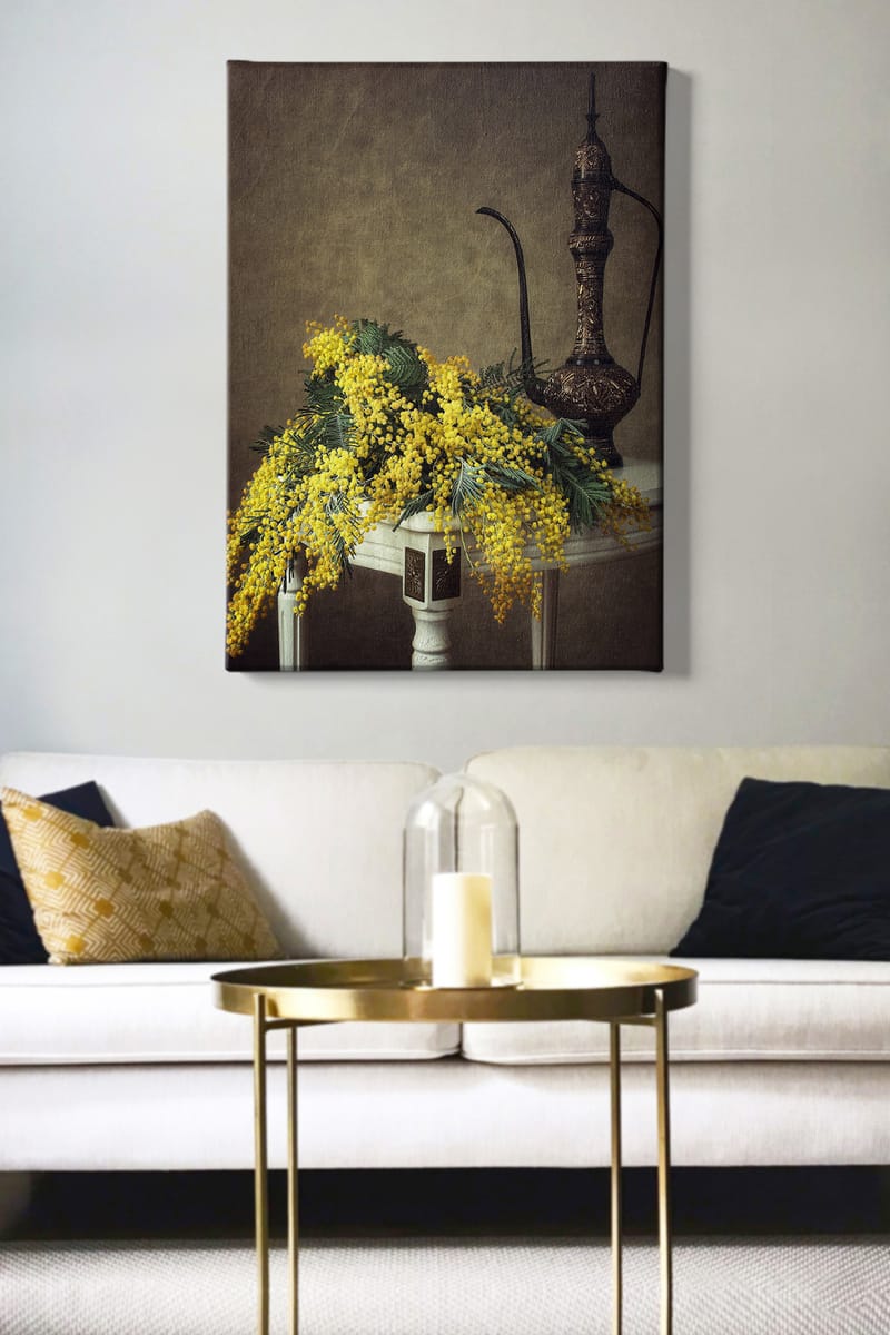 Canvastavla 70x100 cm - Vacker bukett av mimosa blommor i gult, placerad på ett bord bredvid en elegant, mörkbrun kanna - Gult / Mörkgrönt / Brunt - Inredning & dekor - Tavlor & konst - Canvastavla