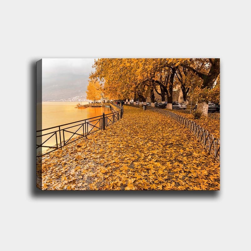 Canvastavla 70x100 cm - Vacker höstscen med gyllene löv som täcker en promenadväg vid en sjö, Guldorange / Mörkgul / Brun