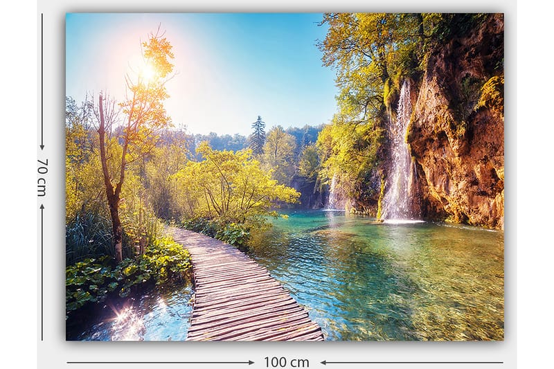 Canvastavla 70x100 cm - Vacker naturvy med en träbro som leder genom grönskande landskap och en vattenfall i bakgrunden - Grön / Blå / Gul - Inredning & dekor - Tavlor & konst - Canvastavla