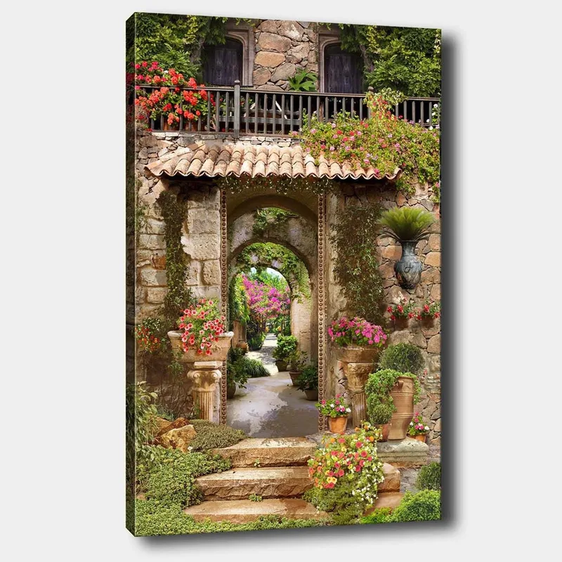 Canvastavla 70x100 cm - Vacker och grönskande trädgård med blomsterarrangemang och en stenbåge som leder in i en lummig gång, Grön / Rosa / Beige