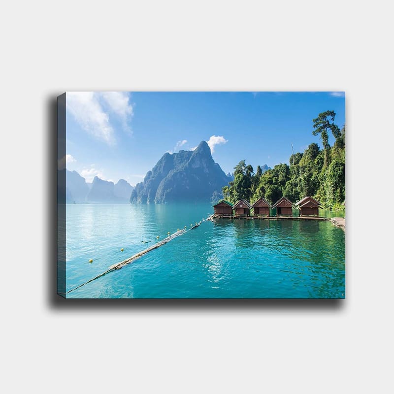 Canvastavla 70x100 cm - Vacker sjö med stugor vid vattnet, omgiven av majestätiska berg och grönskande skog, Turkos / Grön / Brun