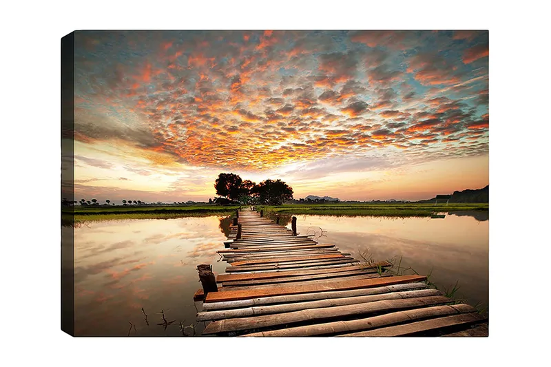 Canvastavla 70x100 cm - Vacker solnedgång över en träbro som sträcker sig över en spegelblanka sjö, Orange / Blå / Grön