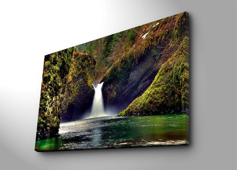 Canvastavla 70x100 cm - Vacker vattenfall som strömmar ner mellan gröna klippor i en naturskön miljö, Grön / Blå / Brun