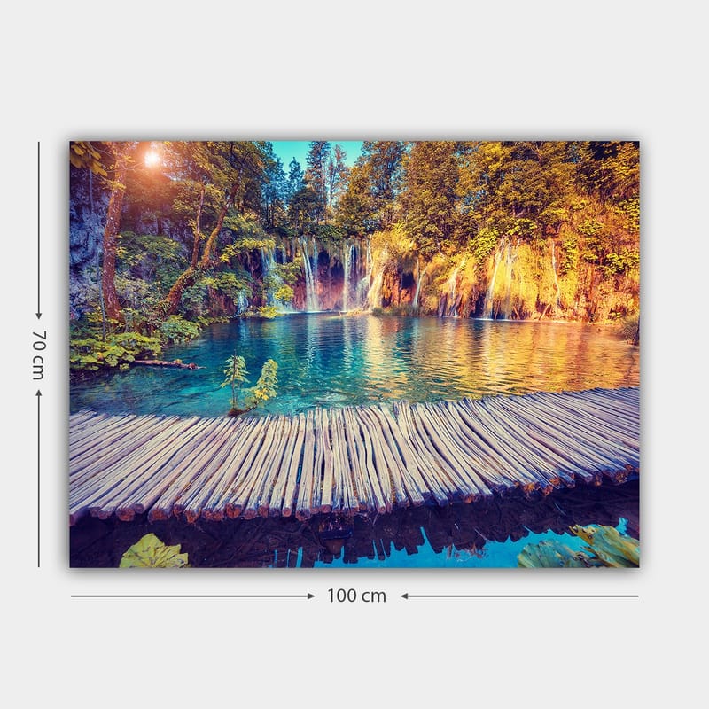 Canvastavla 70x100 cm - Vacker vattenfallsscen med klart blått vatten omgiven av frodig grönska och träd - Blå / Grön / Brun - Inredning & dekor - Tavlor & konst - Canvastavla