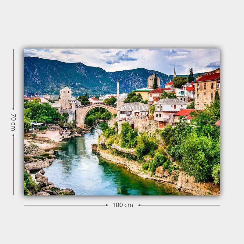 Canvastavla 70x100 cm - Vacker vy över en historisk bro som sträcker sig över en flod, omgiven av pittoreska hus och grönskande landskap - Grön / Blå / Röd - Inredning & dekor - Tavlor & konst - Canvastavla