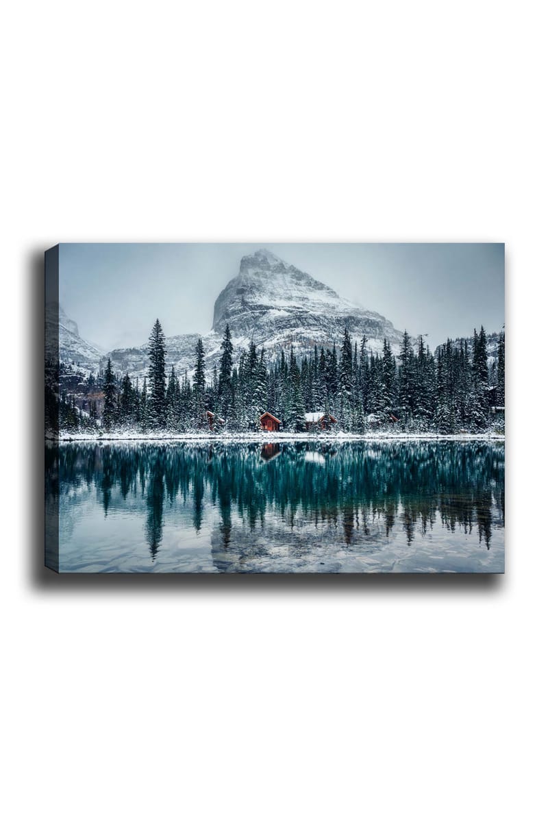 Canvastavla 70x100 cm - Vinterlandskap med snötäckta berg och en spegelblanka sjö omgiven av granar och röda stugor, Mörkgrön / Blå / Vit