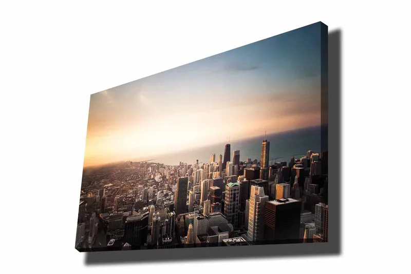 Canvastavla 70x100 cm - Panoramavy av en stad med höga skyskrapor och en solnedgång som skapar en dramatisk atmosfär, Blå / Orange / Grå