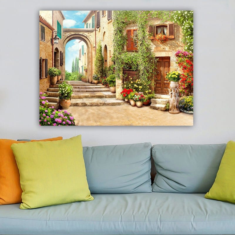 Canvastavla 70x100 cm - Pittoresk gata med blommor och grönska i en charmig bymiljö - Grön / Gul / Rosa - Inredning & dekor - Tavlor & konst - Canvastavla