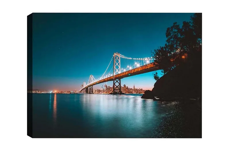 Canvastavla - Ljusbelyst bro över en stilla vattenyta med stadssilhuett i bakgrunden, Blå / Orange / Svart