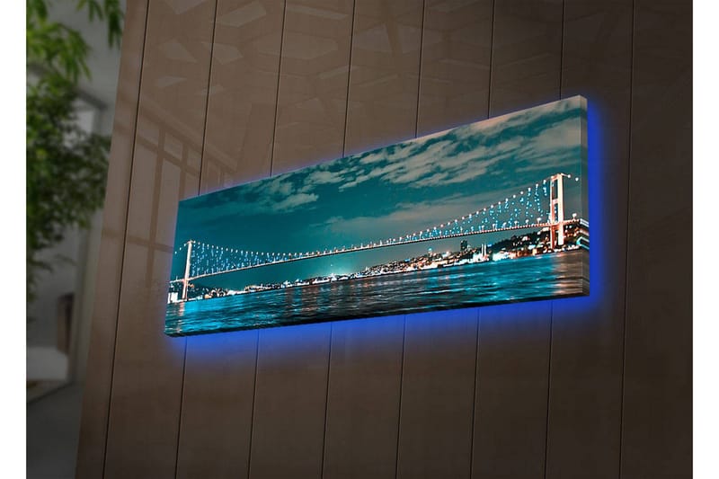 Canvastavla med LED-belysning 30x90 cm - Bro över en stilla vattenyta med stadsljus i bakgrunden, Mörkblå / Turkos / Ljusgrön