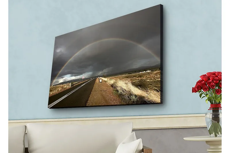 Canvastavla med LED-belysning - Regnbåge som sträcker sig över en mörk himmel ovanför en landsväg, Mörkgrå / Beige / Regnbågsfärger